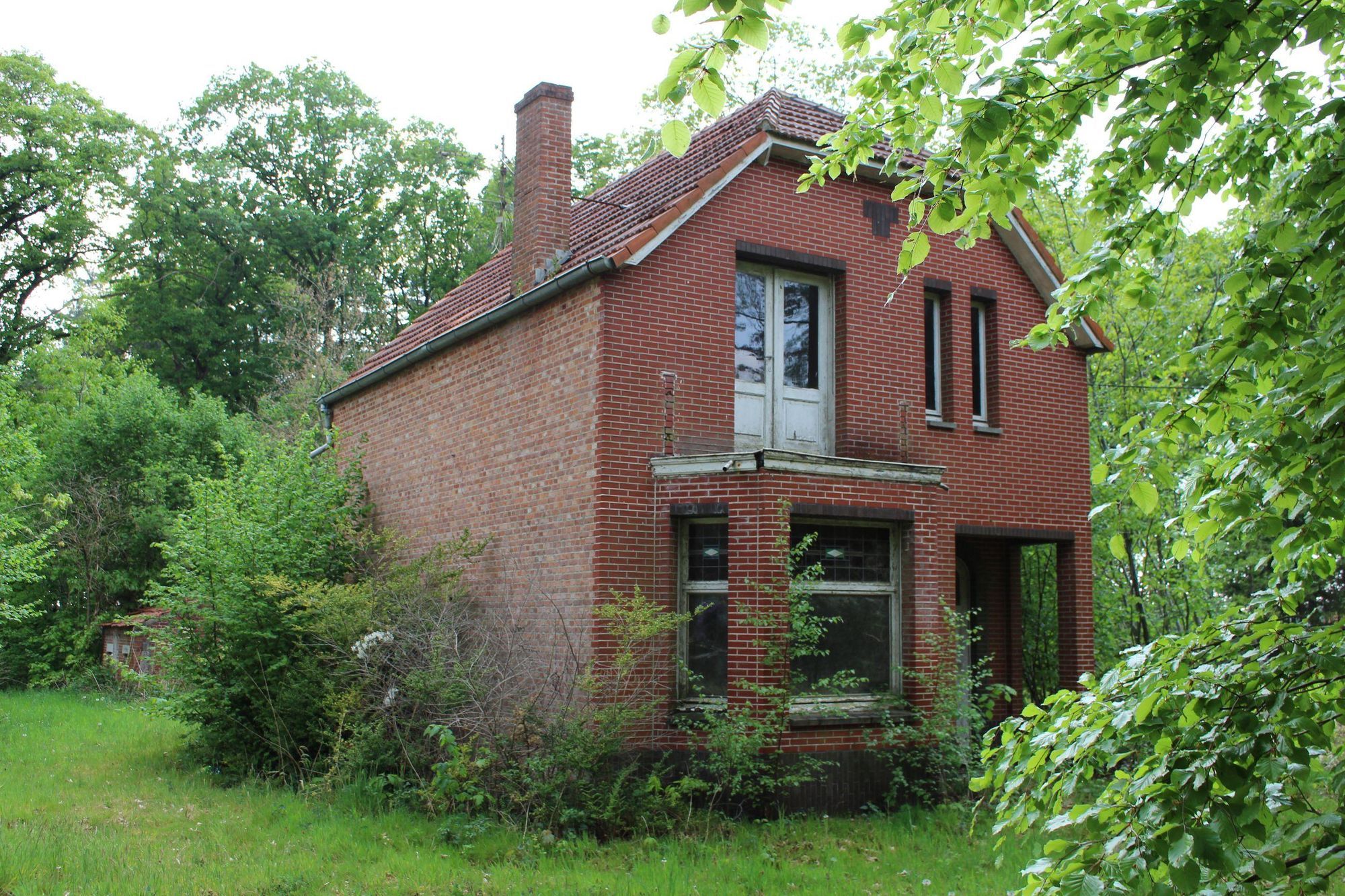 a photograph of an abandoned brick house in belgium
