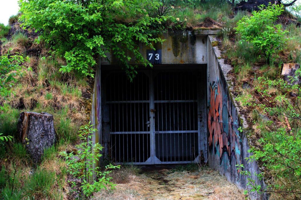 a photograph of the entrance of a bunker. the bunker entrance has the number 73 written on it