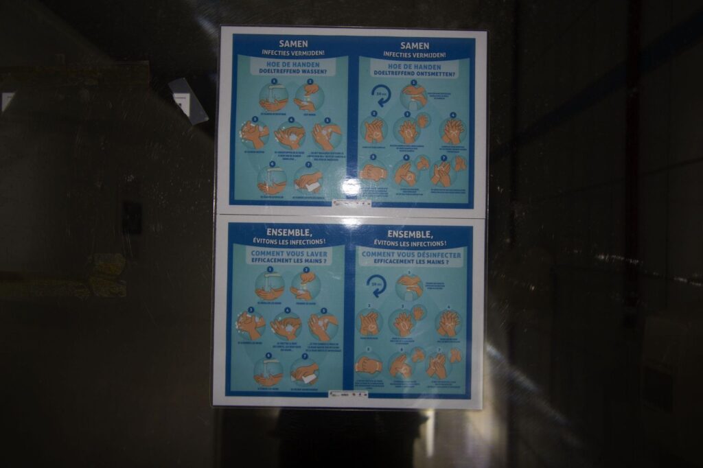 a photograph of covid warning stickers on a mirror in a military bunker