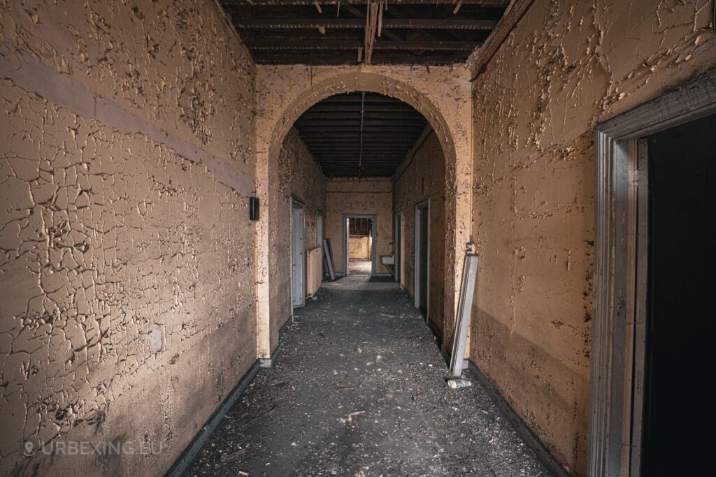 a picture of a hallway with decaying paint on the walls inside of an abandoned observatory