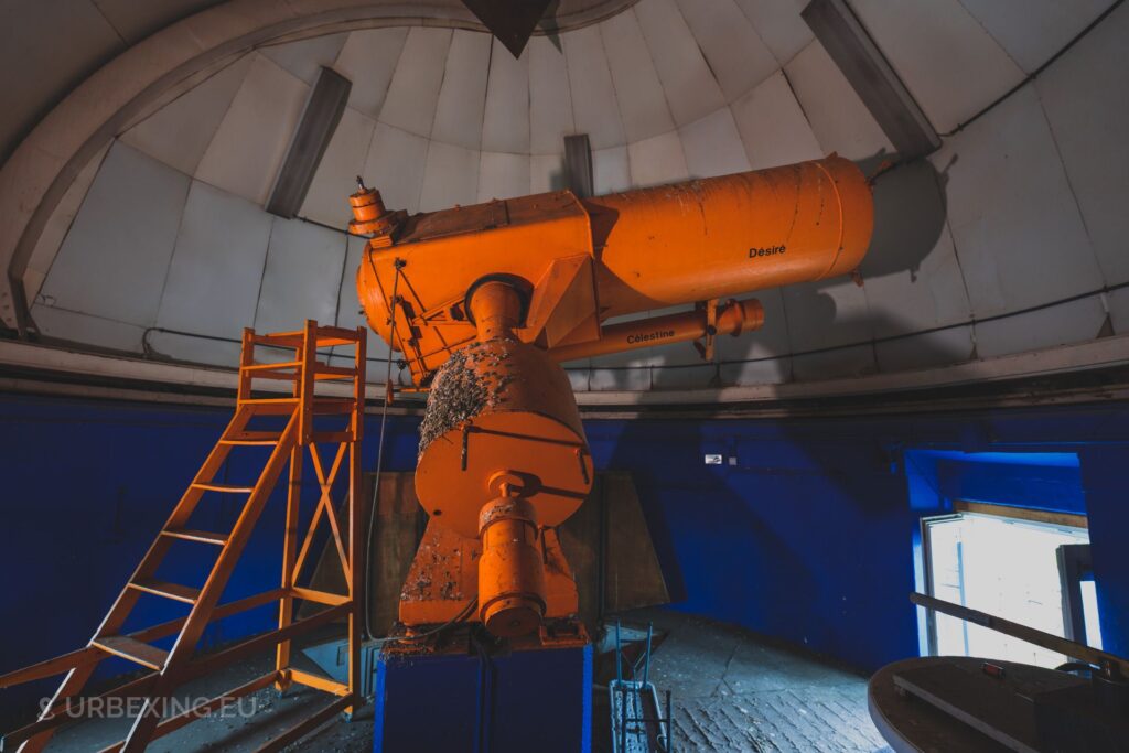 a picture of the desire and celestine telescope in an abandoned observatory
