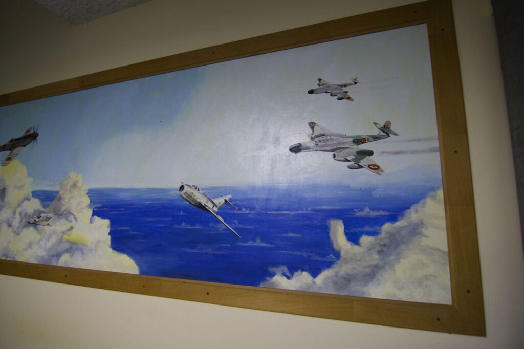 a photograph of one of many paintings with military jets fighting in the air
