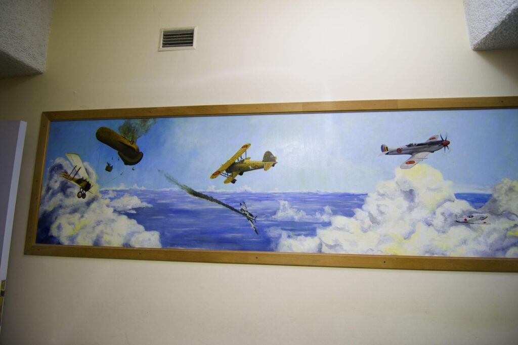 a photograph of a painting with several old war planes flying through the sky and clouds