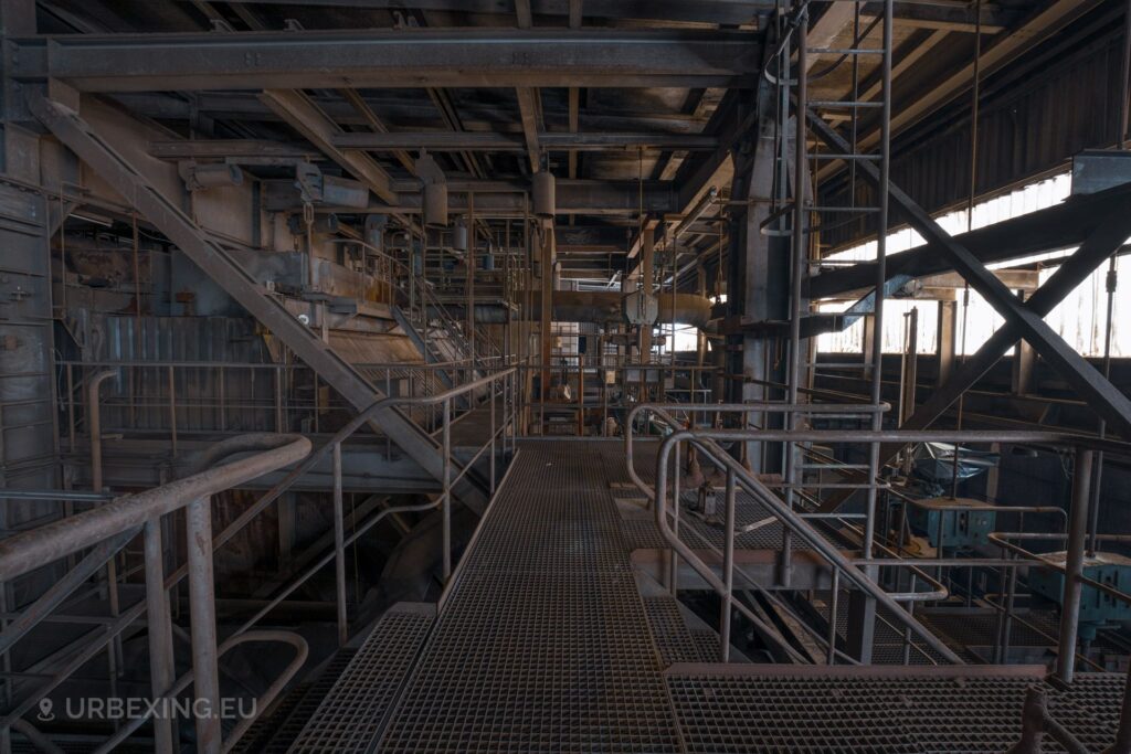 A picture inside the boiler house of an abandoned power plant. The picture shows metal structeds and machinery.