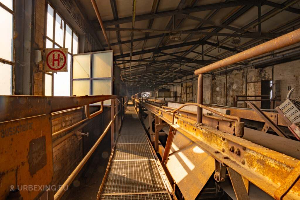 a photograph of the top of the boiler house in a coal fired power plant. the photo shows conveyor belts.