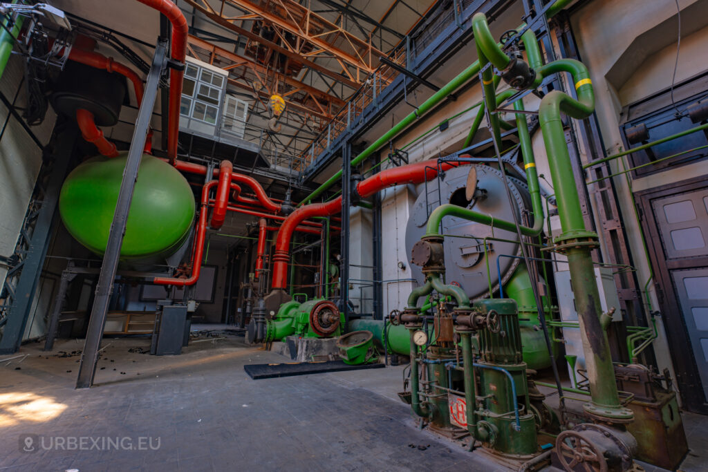 a photograph of the tubing under the turbine in a former power plant. the tubes are colored green and red