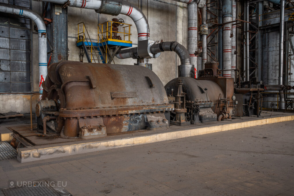 a photograph taken in at an urbex location called blue power plant. the photograph shows a front view of the turbine made by ingersoll-rand. the turbine is rusty