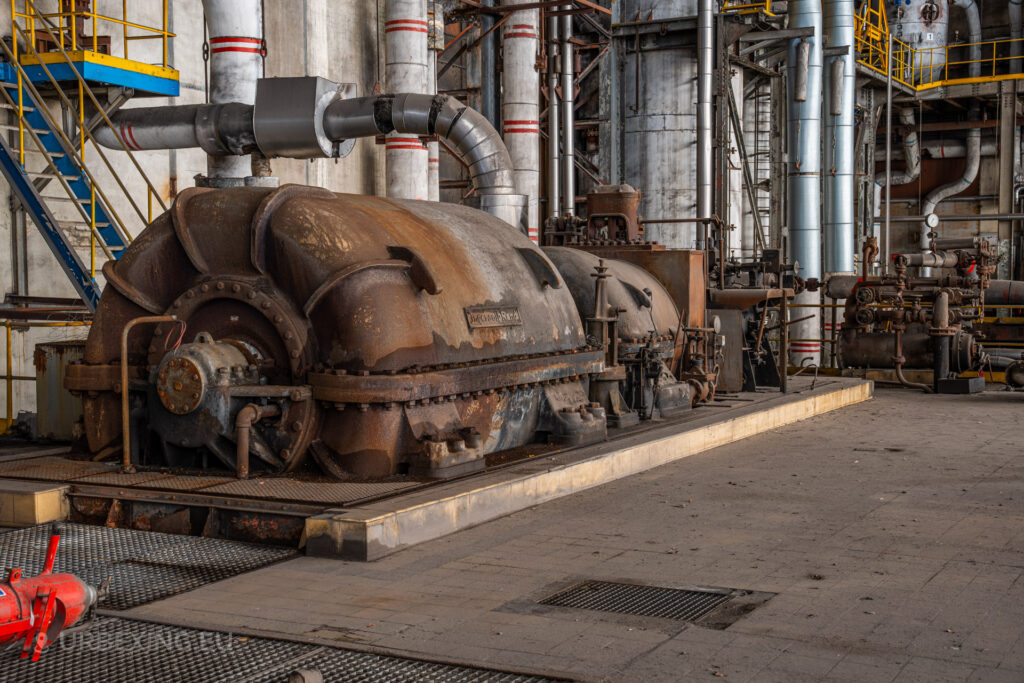 a photograph taken in at an urbex location called blue power plant. the photograph shows a turbine made by ingersoll-rand. the turbine is rusty.
