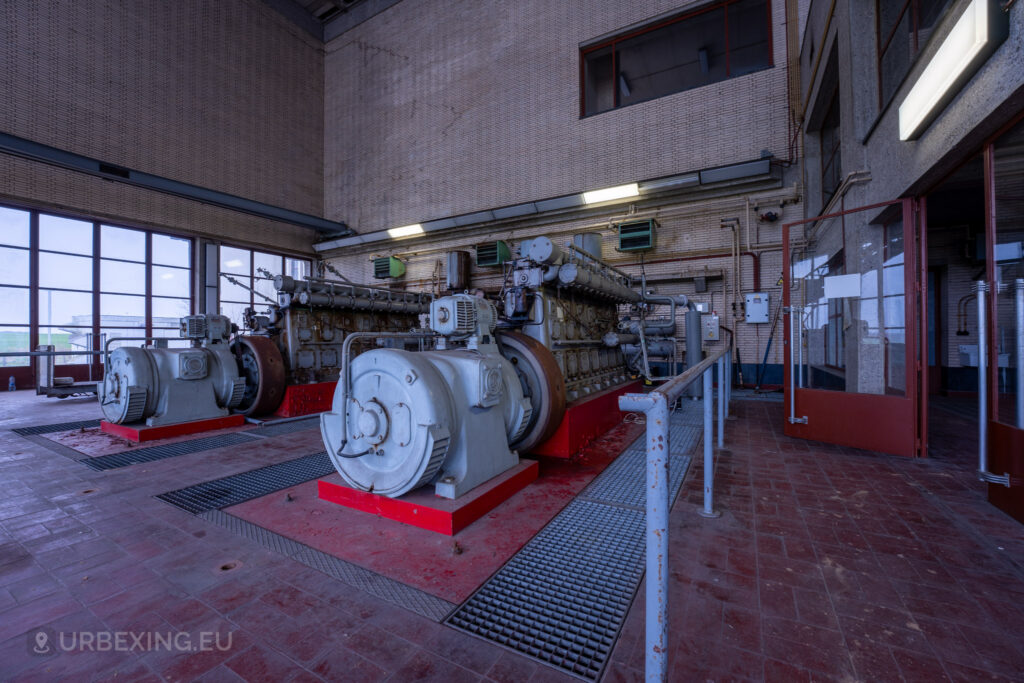 A section of the "Lost Frequencies" facility housing old diesel engines. The rusting machinery and industrial setup, including large motors and piping, are typical of urban exploring scenes that showcase the decay and history of abandoned industrial sites.