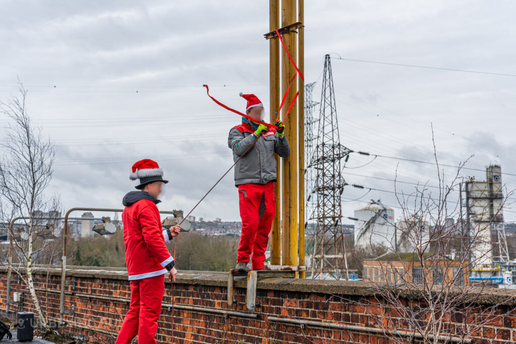 Dressed as Santa, urban explorers add festive decorations to the industrial remnants of the abandoned HF6 power plant in Seraing, Belgium, surrounded by the stark industrial skyline.