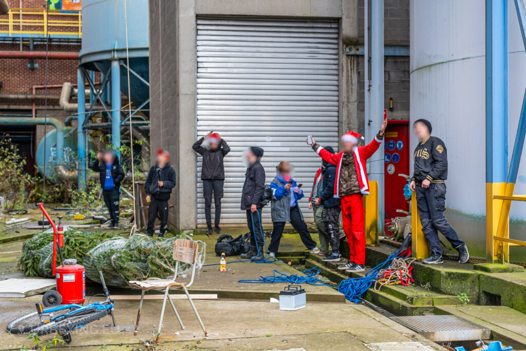 Urban explorers prepare for a festive adventure at the abandoned HF6 power plant in Seraing, Belgium, with a Christmas tree and industrial relics setting the scene for holiday cheer in an unexpected location.