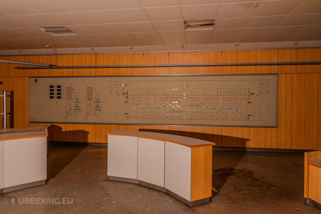 Abandoned control room panel with a detailed schematic diagram on the wall in the Kraftwerk Voerde power station, Voerde, Germany.