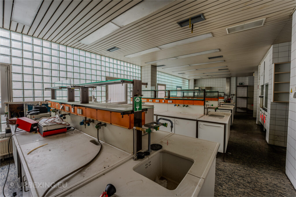 Abandoned laboratory with empty workstations, sinks, and glass block windows inside the Kraftwerk Voerde, Voerde, Germany.