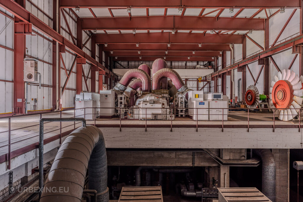 Abandoned turbine hall of Kraftwerk Voerde in Voerde, Germany, showcasing massive industrial machinery and rusted structures.