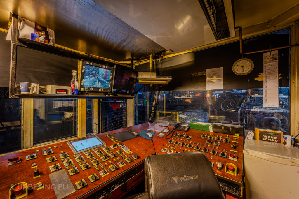 Control room of the abandoned Vallourec steel mill in Düsseldorf-Rath, featuring a vintage control panel, monitors, and signs of industrial decline, providing a glimpse into the operational past of this steel tube manufacturing facility.