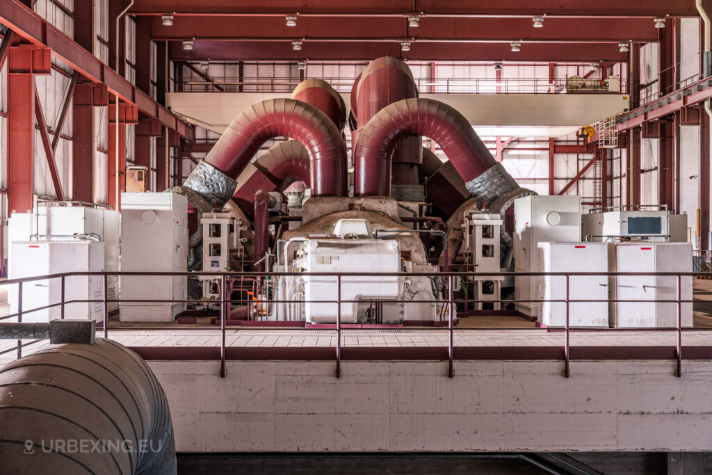 Centered view of red turbines and industrial machinery in the abandoned Kraftwerk Voerde, Voerde, Germany.