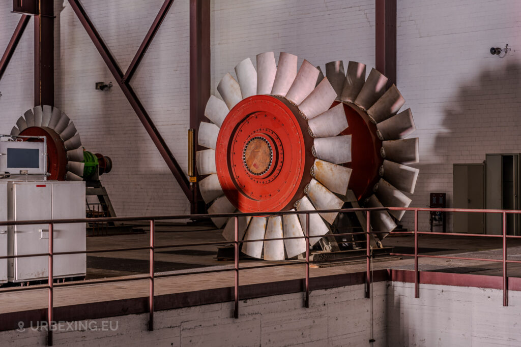 Close-up of a massive red turbine blade in the abandoned Kraftwerk Voerde, Voerde, Germany, surrounded by industrial equipment.