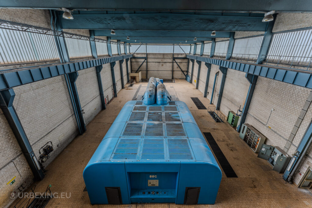 Overhead wide view of the turbine hall with a blue BBC generator in the abandoned Kraftwerk Voerde, Voerde, Germany.