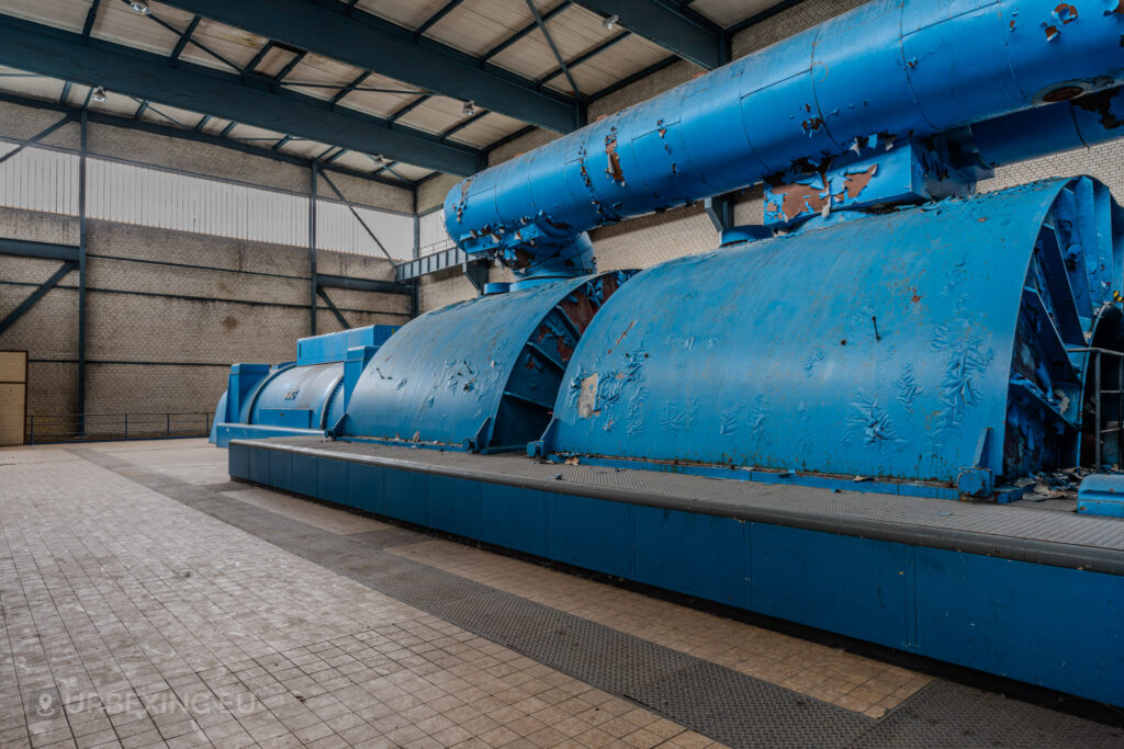 Side view of a weathered blue turbine with peeling paint in the abandoned Kraftwerk Voerde, Voerde, Germany.