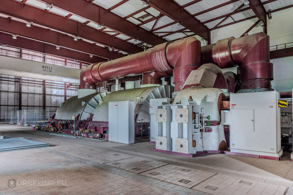 Side view of red turbines and machinery in the turbine hall of the abandoned Kraftwerk Voerde, Voerde, Germany.