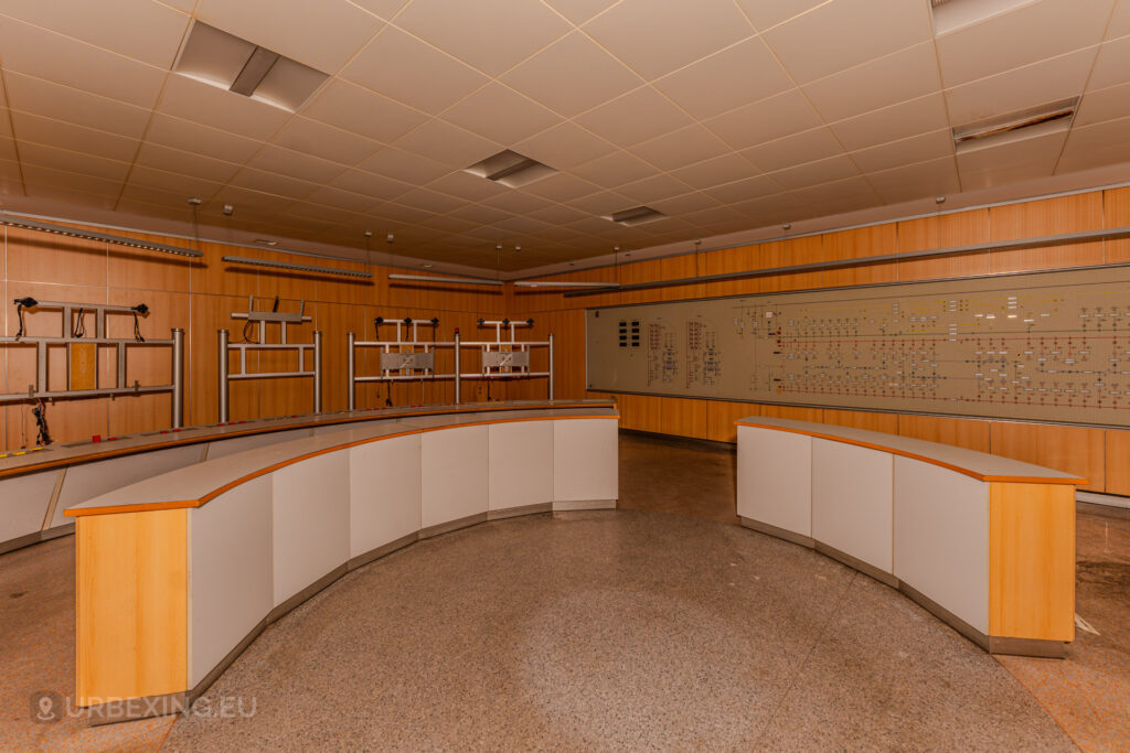 Wide-angle view of the control room in the abandoned Kraftwerk Voerde, Voerde, Germany, with curved desks and schematic panels.