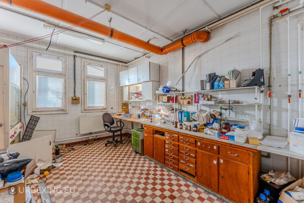 Overview of an abandoned laboratory at a chemical plant in Hungary showing a desk with papers and checmicals
